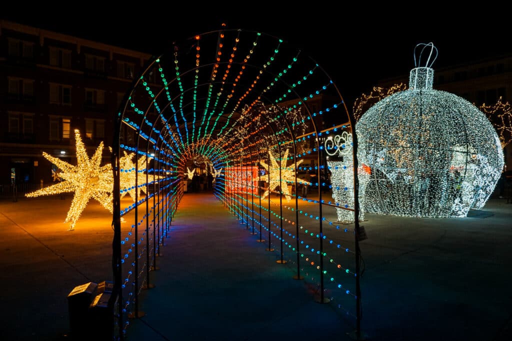A colorful light tunnel, star, and giant ornament at Christmas in the Square in Frisco. 