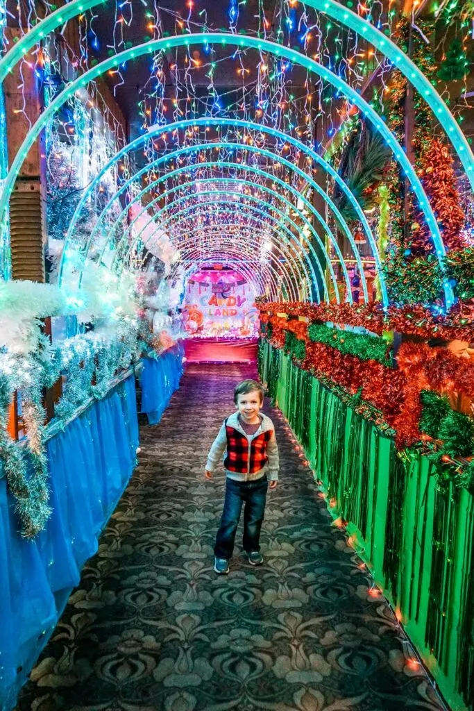 A toddler boy standing in the middle of an epic light tunnel at the most festive restaurant in Dallas - Campo Verde.