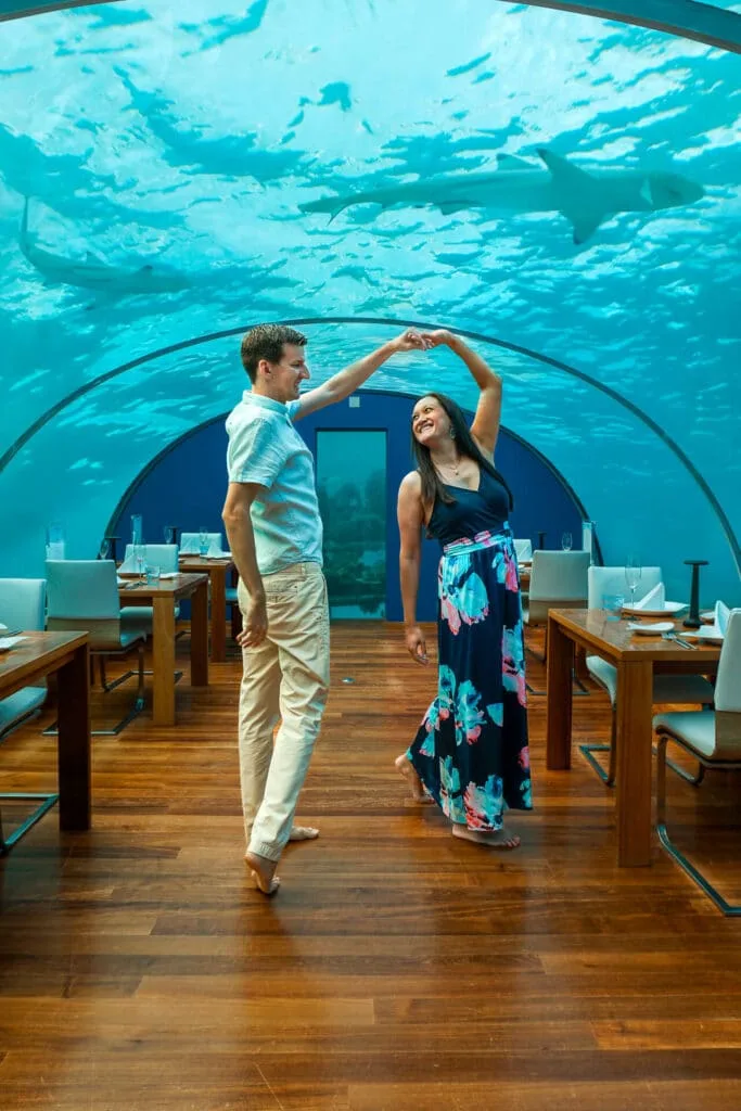 A couple dancing in a dining room 16 ft below sea at Ithaa.