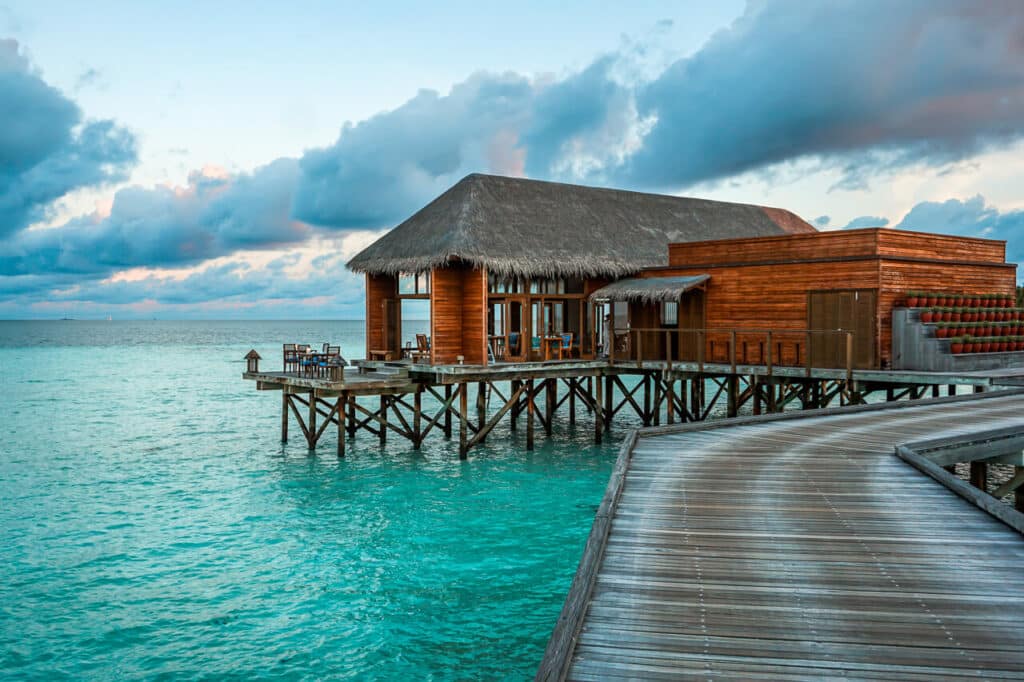 A wooden boardwalk leading to a gorgeous restaurant perched over the Indian Ocean. Restaurant is called Mandhoo at Conrad Maldives Rangali Island. 