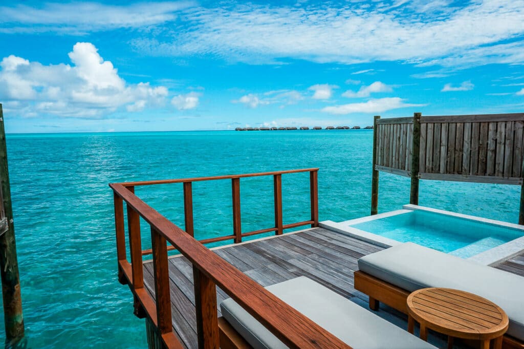 A patio over water with lounge chairs and a plunge pool at Conrad Maldives Rangali Island. A luxurious place you can stay in the Maldives on points.