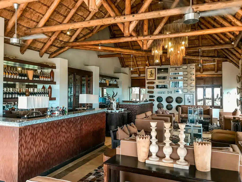 AndBeyond Phinda Mountain Lodge Lounge with African decor, comfy chairs, and an open bar.