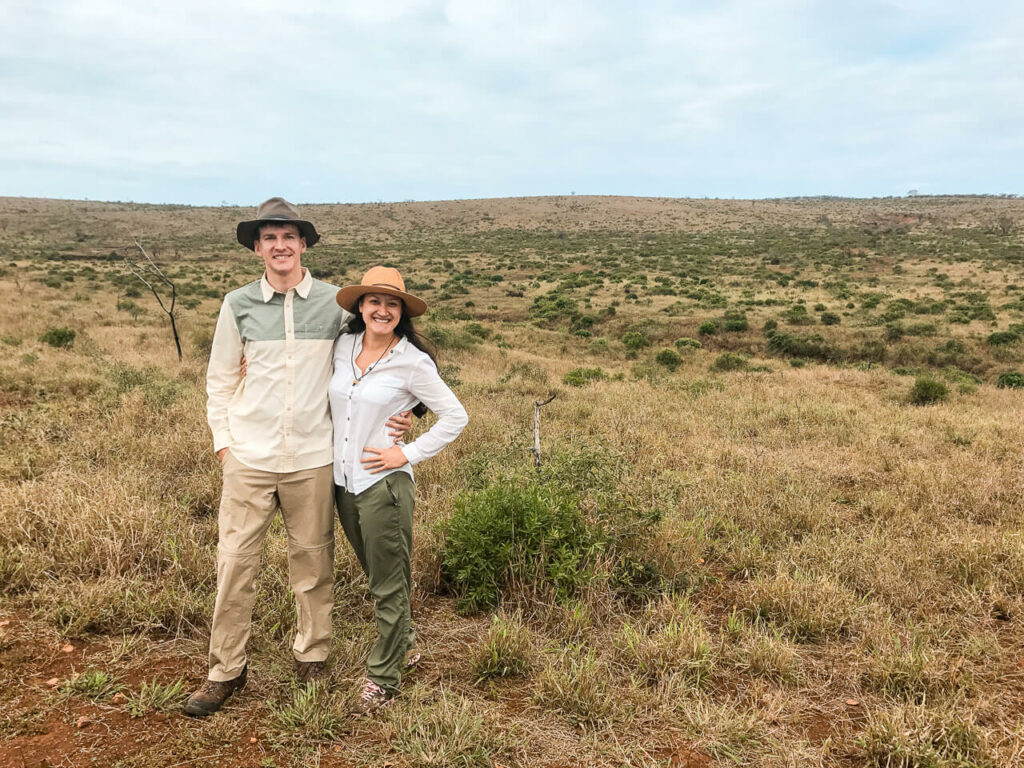 A couple in neutral safari clothes posing for the camera at Phinda Game Reserve.