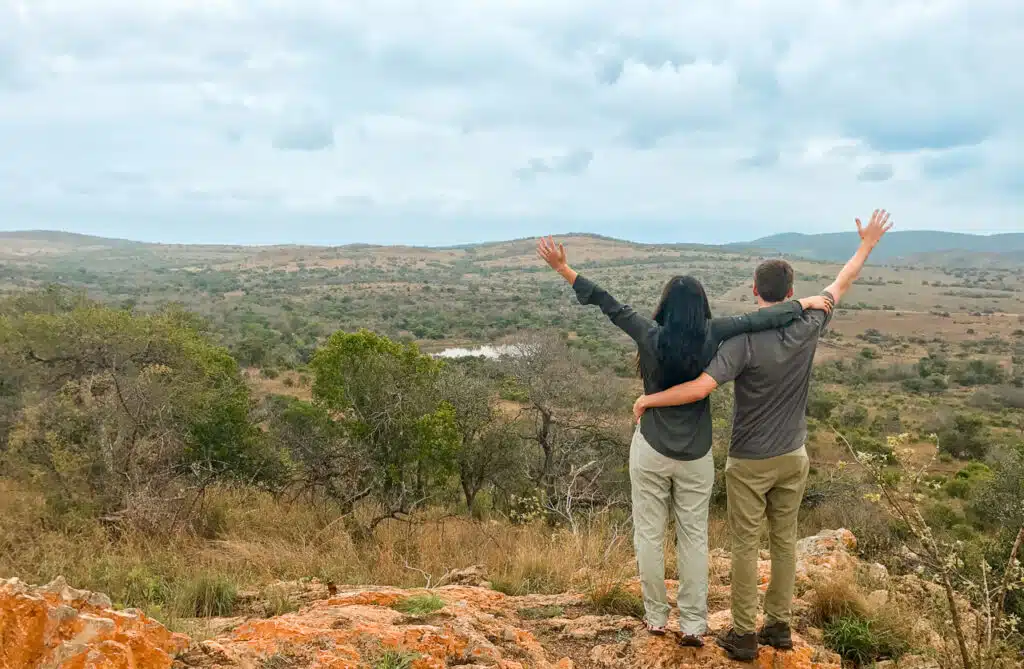 A couple standing in the Phinda Game Reserve bush enjoying the views. 