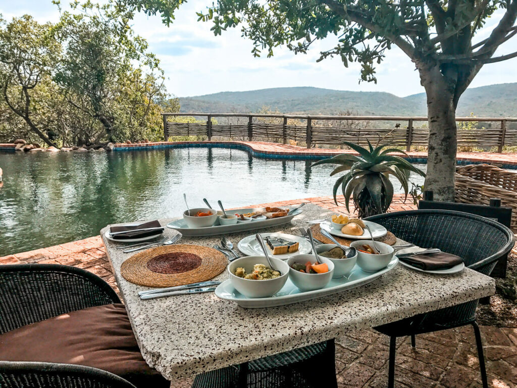 A table with a lunch spread next to a pool at AndBeyond Phinda Mountain Lodge.