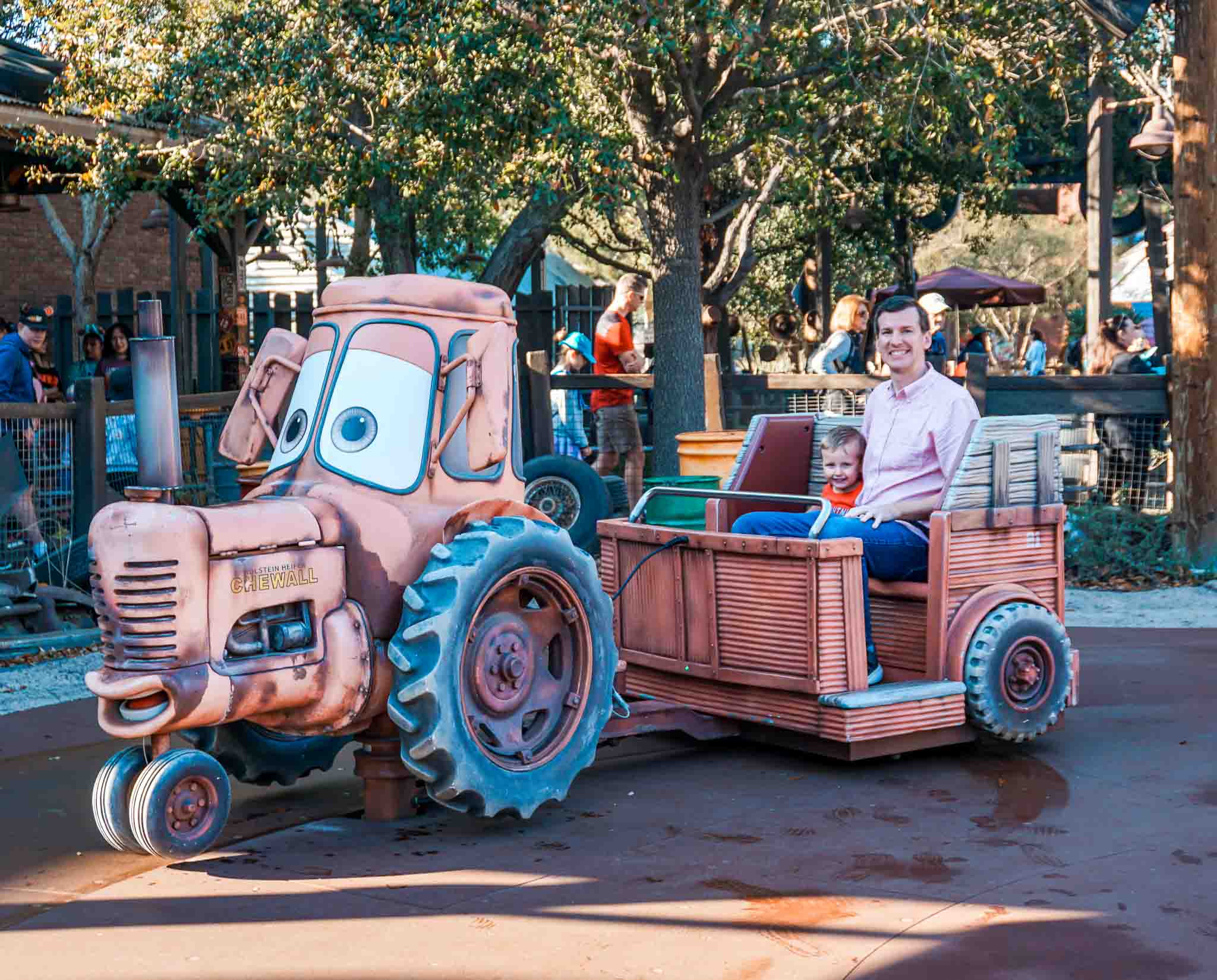 A dad and son on the Mater's Junkyard Jamboree ride at DCA.