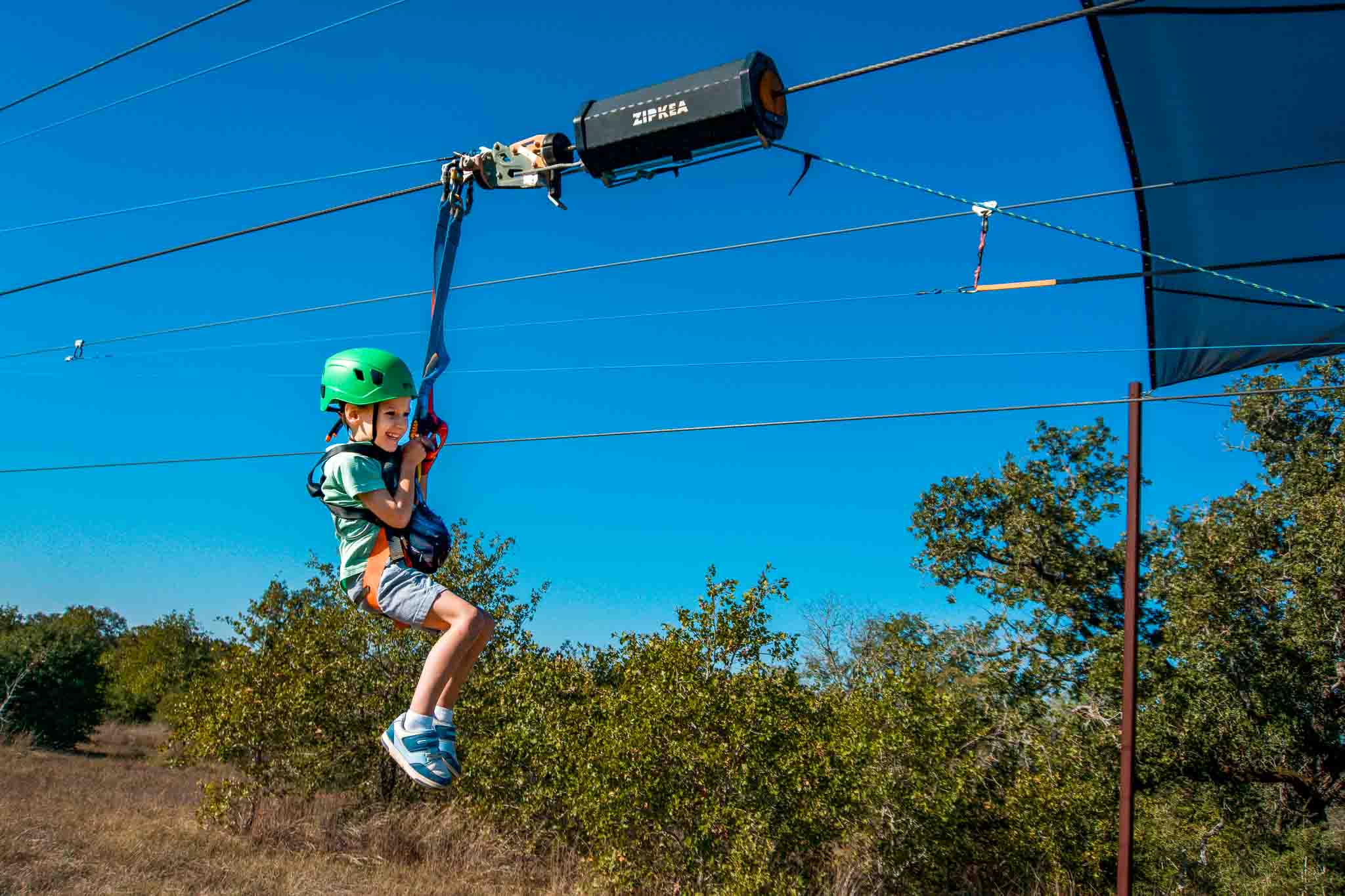 A 5 year old smiling on a zip-line in McKinney Roughs Nature Park.