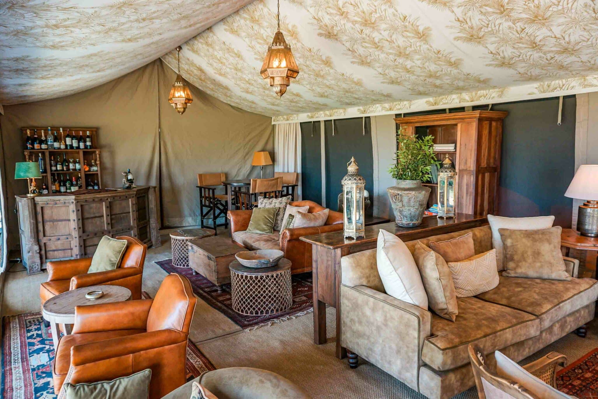 A gorgeous commons area inside a luxury tent with timeless decor and furniture at Elewana Elephant Pepper Camp.